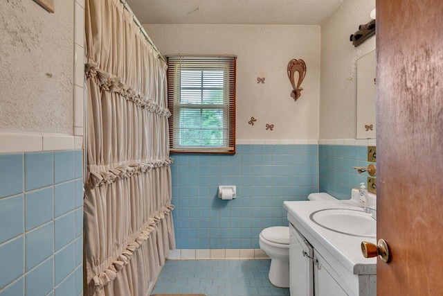 1006 Hillcrest Cir, Pleasant View, TN 37146 - full bathroom featuring tile patterned floors, tile walls, toilet, vanity, and wainscoting