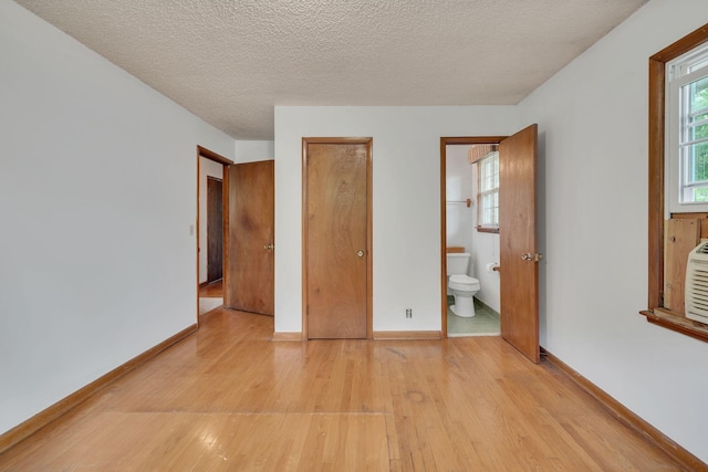 1006 Hillcrest Cir, Pleasant View, TN 37146 - unfurnished bedroom featuring light wood-type flooring, baseboards, ensuite bathroom, and a textured ceiling