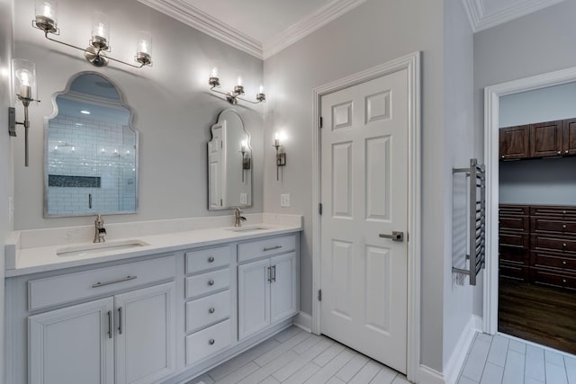 bathroom with tiled shower, double vanity, crown molding, and baseboards