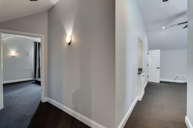 corridor with dark carpet, vaulted ceiling, baseboards, and recessed lighting