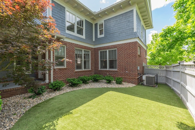 rear view of property with central AC unit and brick siding