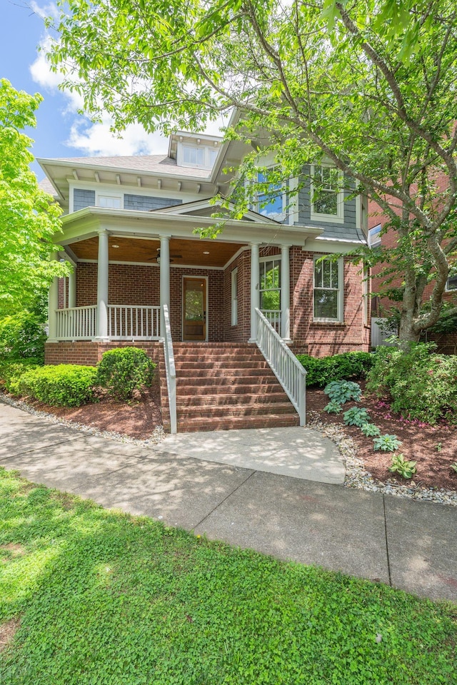 view of front of home featuring covered porch and brick siding