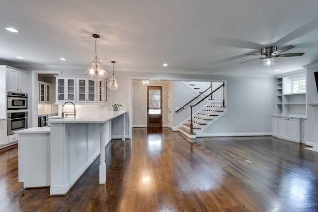 kitchen featuring glass insert cabinets, light countertops, white cabinetry, a ceiling fan, and recessed lighting