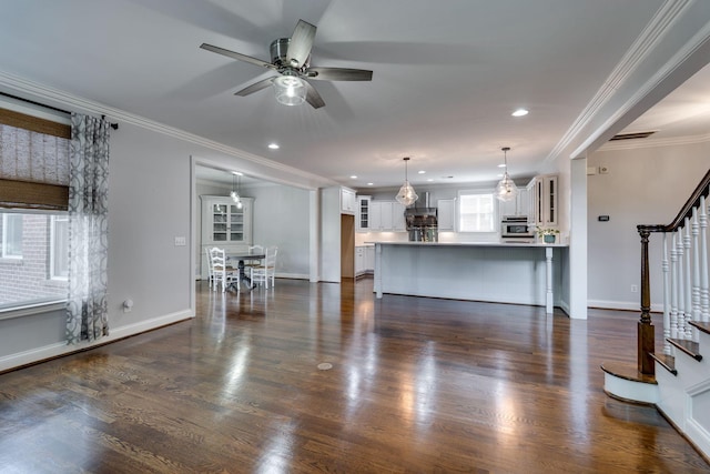 living area featuring stairway, crown molding, ceiling fan, baseboards, and recessed lighting