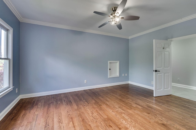 empty room with plenty of natural light, baseboards, a ceiling fan, crown molding, and wood finished floors