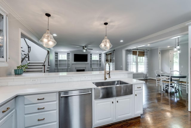 kitchen with stainless steel dishwasher, a sink, a ceiling fan, open floor plan, and ornamental molding