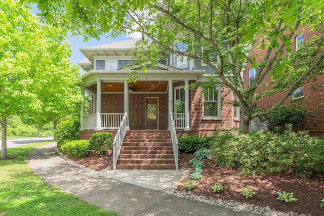 traditional style home featuring covered porch, a ceiling fan, and brick siding