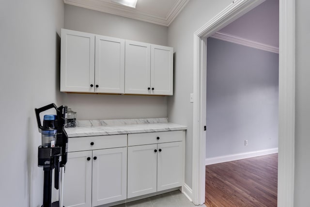 bar featuring ornamental molding, baseboards, and light wood-type flooring