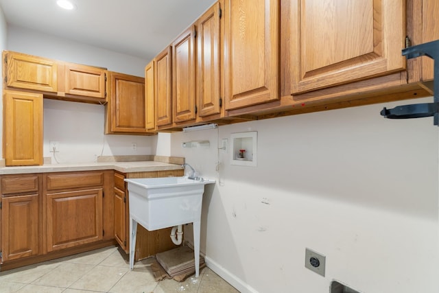 washroom with hookup for an electric dryer, hookup for a washing machine, light tile patterned floors, baseboards, and cabinet space