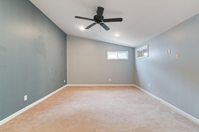 carpeted empty room with lofted ceiling, ceiling fan, and baseboards