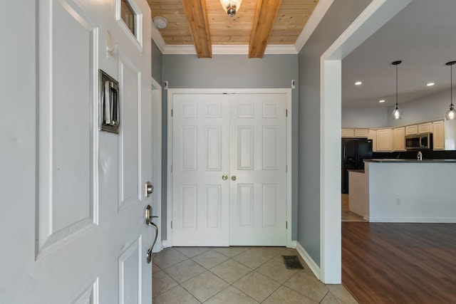 entrance foyer featuring wooden ceiling, light tile patterned floors, beam ceiling, recessed lighting, and baseboards
