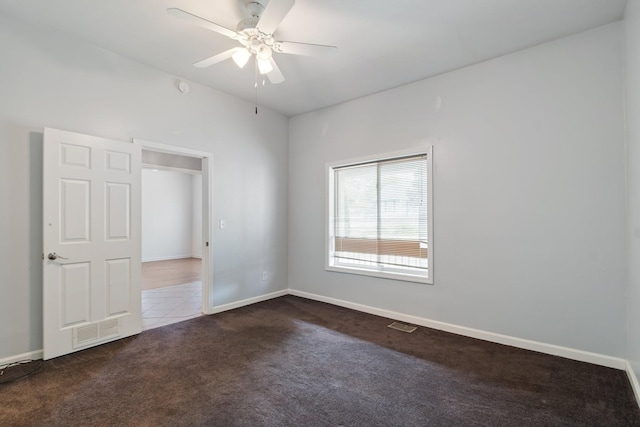unfurnished room featuring carpet floors, a ceiling fan, and baseboards
