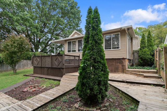 back of house with a fenced backyard and a wooden deck