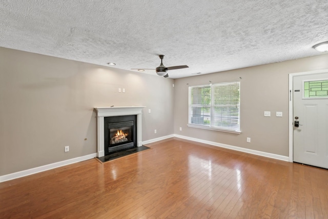 325 Golfview Ln, Springfield, TN 37172 - unfurnished living room featuring a fireplace with flush hearth, ceiling fan, a textured ceiling, hardwood / wood-style flooring, and baseboards