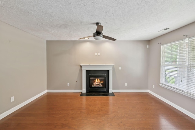 325 Golfview Ln, Springfield, TN 37172 - unfurnished living room featuring wood finished floors, a fireplace with flush hearth, a ceiling fan, a textured ceiling, and baseboards