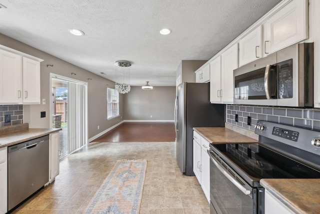 325 Golfview Ln, Springfield, TN 37172 - kitchen with appliances with stainless steel finishes, white cabinets, backsplash, a textured ceiling, and hanging light fixtures