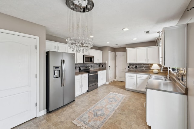 325 Golfview Ln, Springfield, TN 37172 - kitchen with stainless steel appliances, backsplash, white cabinets, a chandelier, and a sink