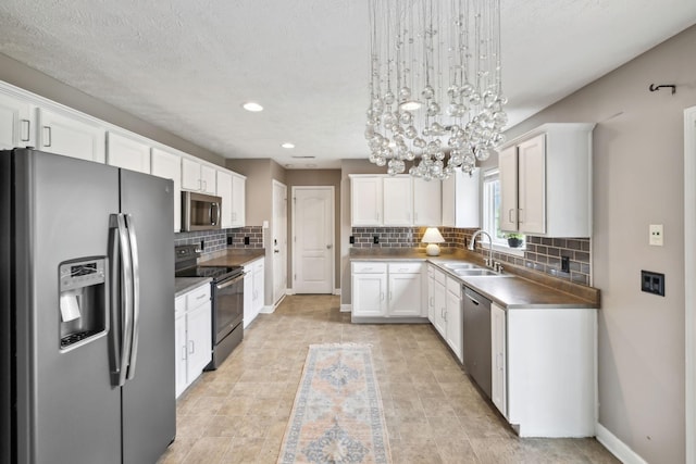 325 Golfview Ln, Springfield, TN 37172 - kitchen with stainless steel appliances, a chandelier, a sink, white cabinetry, and tasteful backsplash