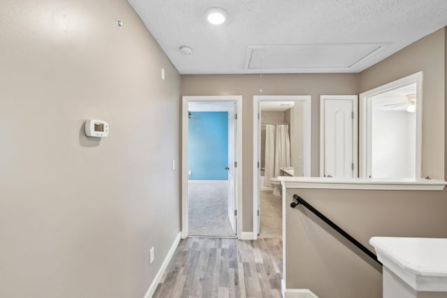 325 Golfview Ln, Springfield, TN 37172 - hall with attic access, light wood-style flooring, baseboards, a textured ceiling, and an upstairs landing