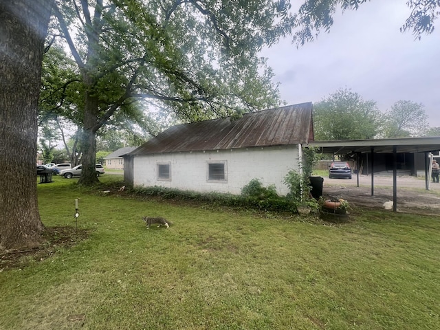 207 Powell St, Decherd, TN 37324 - view of property exterior featuring a lawn, concrete block siding, and a carport