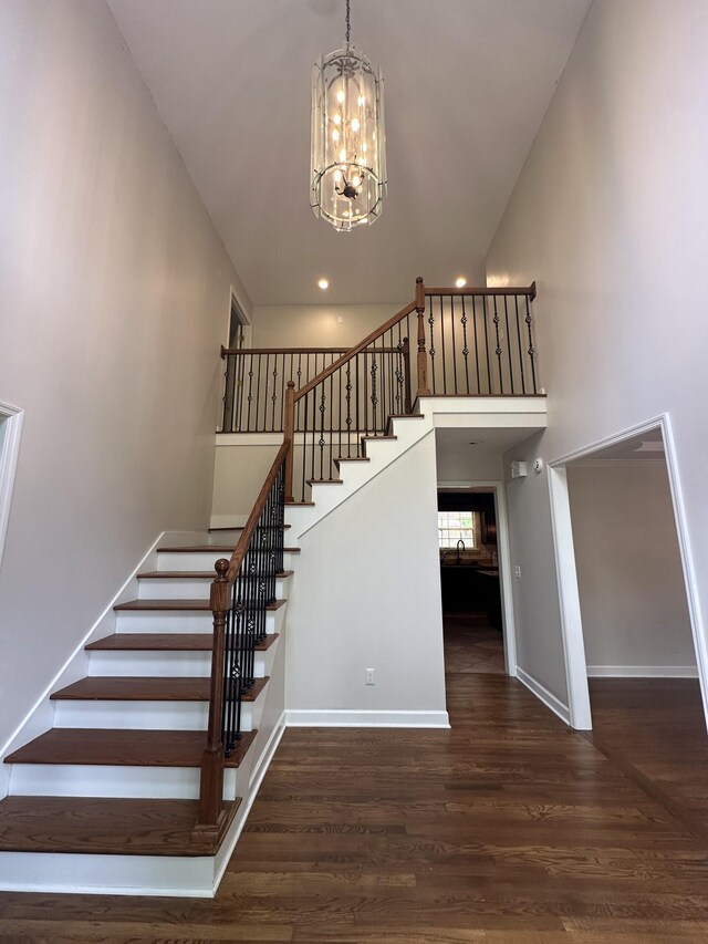6900 Snow View Ln, Ooltewah, TN 37363 - stairway featuring a chandelier, wood finished floors, baseboards, a high ceiling, and recessed lighting