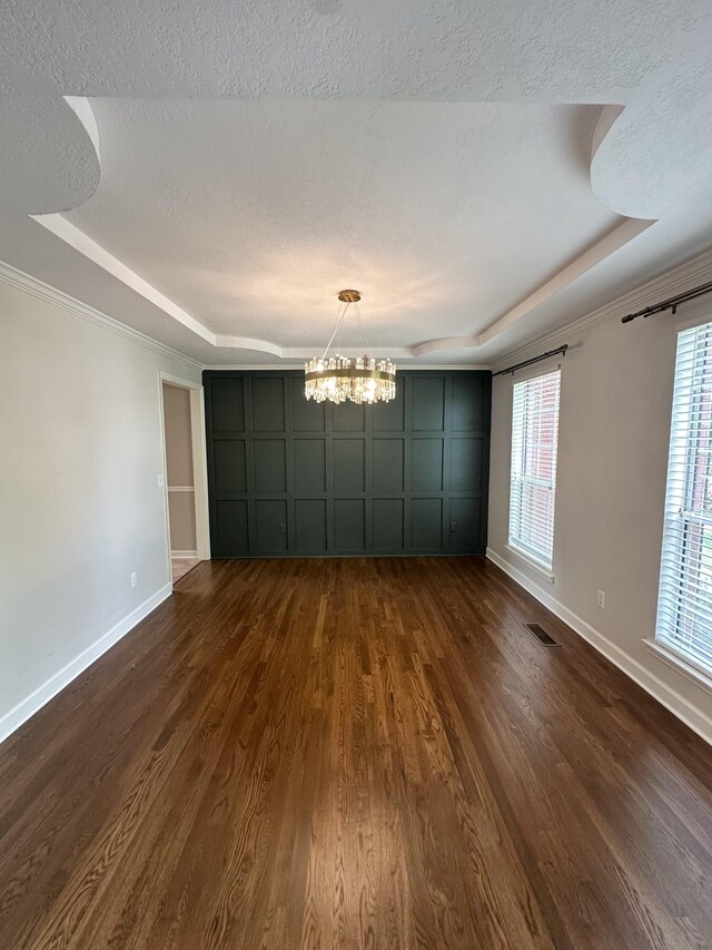 6900 Snow View Ln, Ooltewah, TN 37363 - empty room featuring a tray ceiling, a chandelier, baseboards, dark wood-style floors, and a textured ceiling