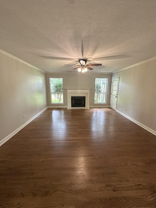 6900 Snow View Ln, Ooltewah, TN 37363 - unfurnished living room featuring a textured ceiling, ornamental molding, baseboards, dark wood-type flooring, and healthy amount of natural light