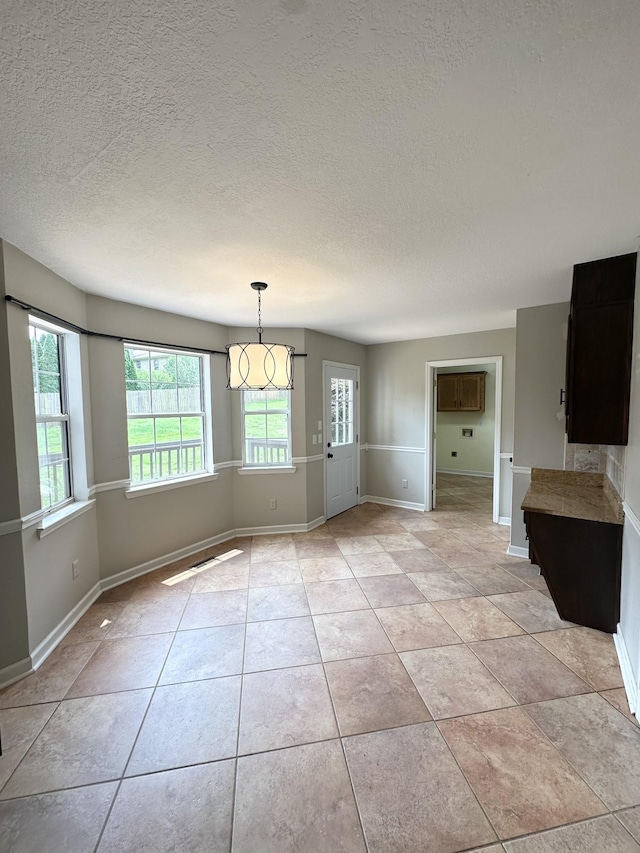 6900 Snow View Ln, Ooltewah, TN 37363 - unfurnished dining area with a textured ceiling, baseboards, and light tile patterned floors