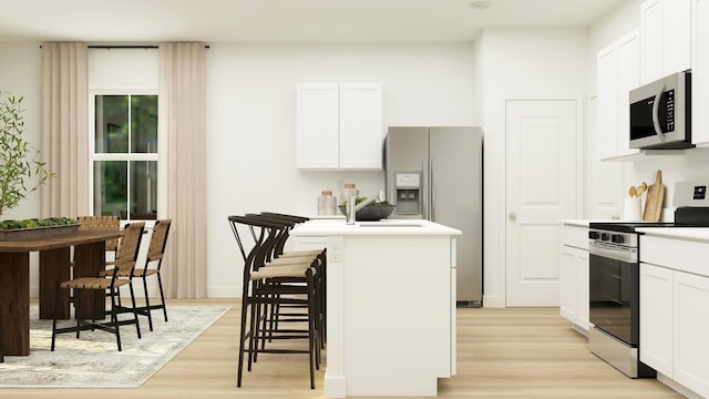 kitchen with stainless steel appliances, a kitchen island, light wood-type flooring, white cabinetry, and light countertops