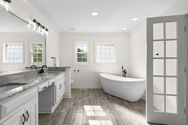 754 Veterans Pkwy, Murfreesboro, TN 37128 - bathroom with crown molding, baseboards, wood finished floors, a freestanding bath, and toilet