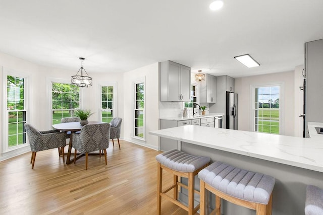 754 Veterans Pkwy, Murfreesboro, TN 37128 - kitchen featuring gray cabinetry, stainless steel appliances, a sink, light wood-type flooring, and a breakfast bar