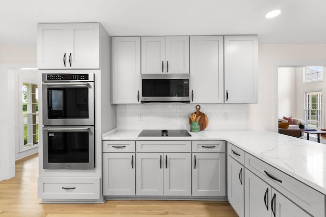 754 Veterans Pkwy, Murfreesboro, TN 37128 - kitchen featuring appliances with stainless steel finishes, light stone countertops, tasteful backsplash, light wood-style floors, and recessed lighting