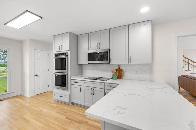 754 Veterans Pkwy, Murfreesboro, TN 37128 - kitchen featuring stainless steel appliances, backsplash, light wood finished floors, light stone counters, and gray cabinets