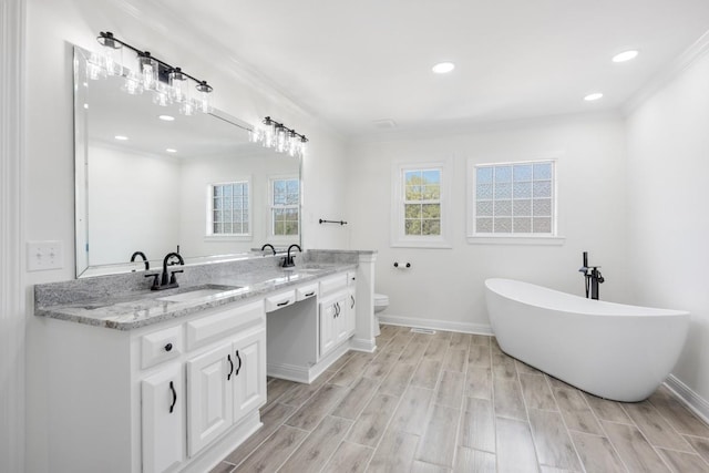 754 Veterans Pkwy, Murfreesboro, TN 37128 - bathroom with ornamental molding, double vanity, a freestanding bath, toilet, and wood finished floors