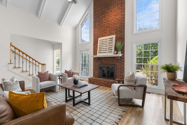 754 Veterans Pkwy, Murfreesboro, TN 37128 - living room featuring high vaulted ceiling, beam ceiling, wood finished floors, stairway, and a brick fireplace