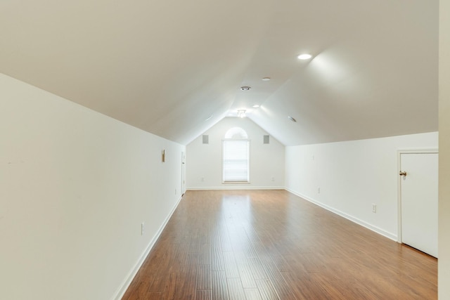 bonus room featuring vaulted ceiling, baseboards, and wood finished floors