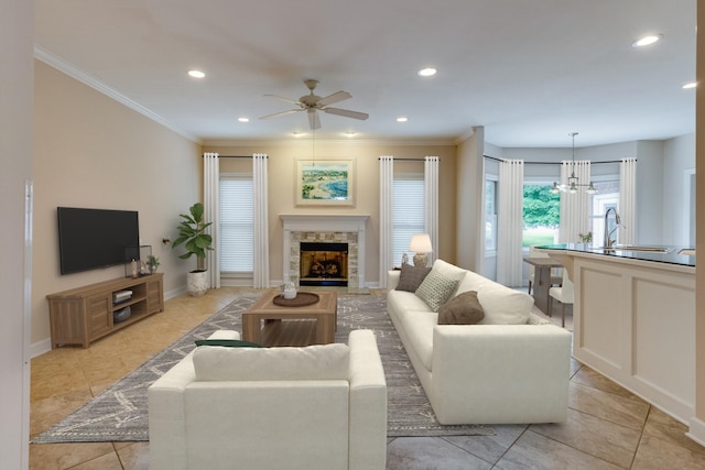 living room with ceiling fan, recessed lighting, ornamental molding, light tile patterned floors, and a fireplace