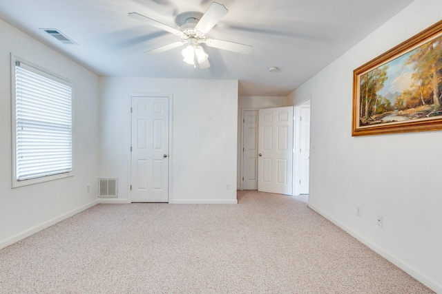 unfurnished bedroom featuring light colored carpet, baseboards, and a ceiling fan