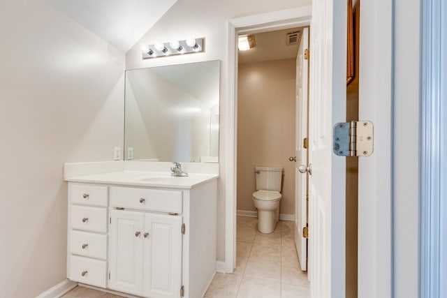 bathroom with toilet, vanity, tile patterned flooring, lofted ceiling, and baseboards