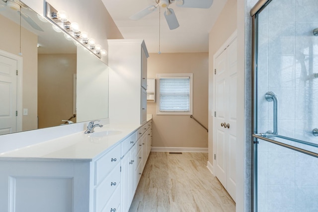 full bathroom featuring a ceiling fan, tiled shower, vanity, marble finish flooring, and baseboards