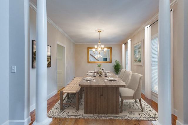 dining space featuring light wood-style floors, baseboards, a chandelier, and ornamental molding