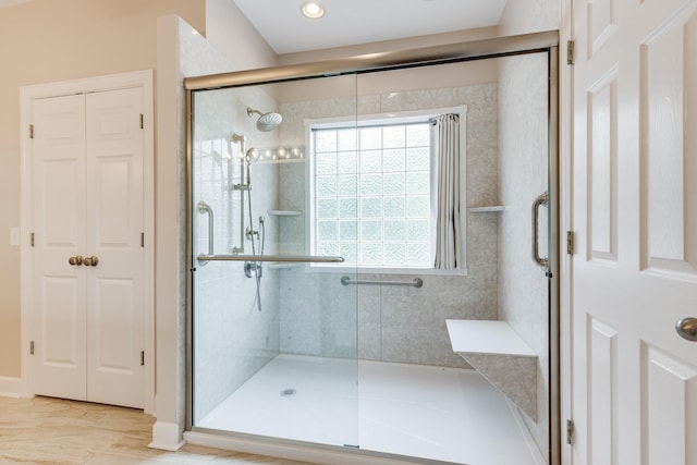 bathroom with a shower stall and a closet