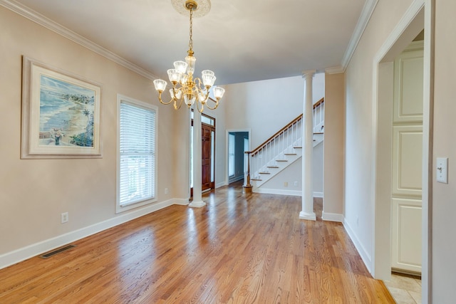 foyer with light wood finished floors, a chandelier, baseboards, crown molding, and stairway