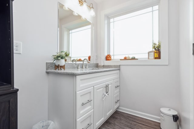 bathroom with vanity, wood finished floors, and baseboards
