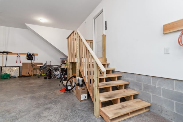 staircase featuring concrete block wall