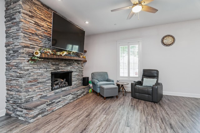 living area featuring wood finished floors, baseboards, a fireplace, and recessed lighting