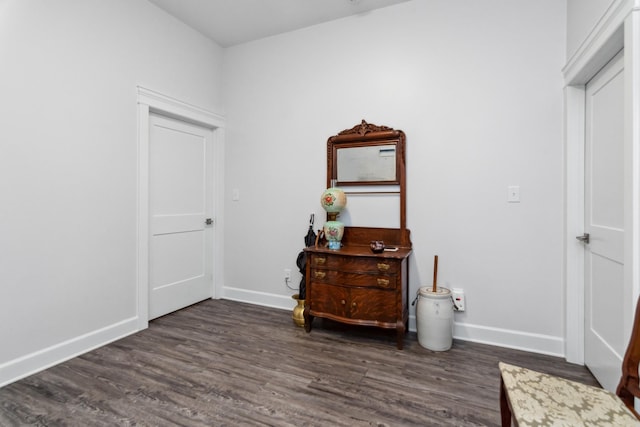 bedroom with dark wood-type flooring and baseboards