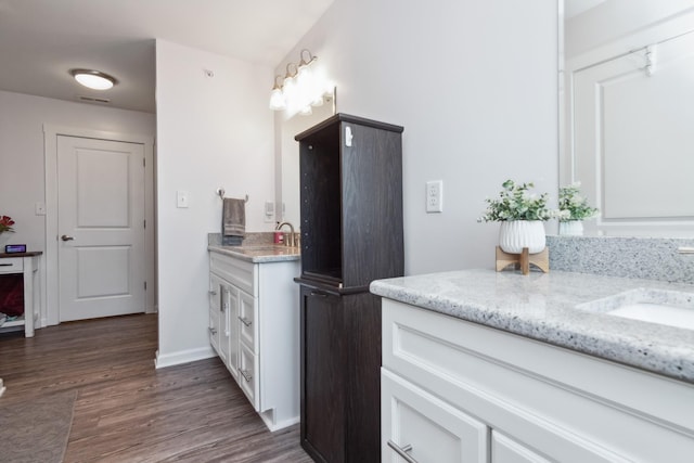 bathroom featuring vanity, wood finished floors, and baseboards