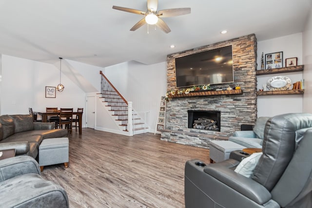 living area with stairway, a ceiling fan, wood finished floors, baseboards, and recessed lighting