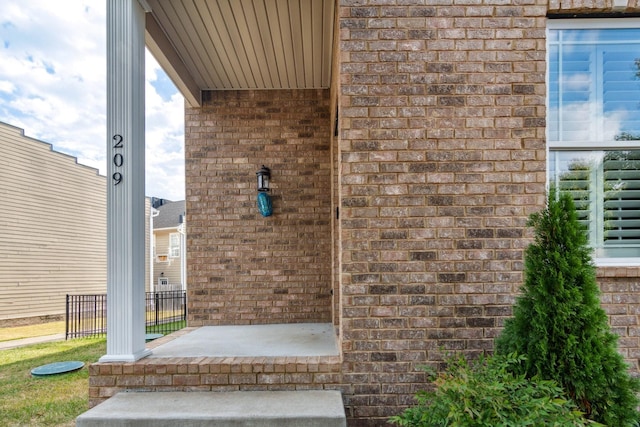 property entrance featuring brick siding and a porch